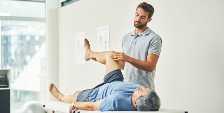 Image d'un kiné en train de manipuler la jambe d'un patient